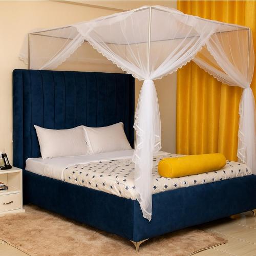 a bedroom with a blue bed with a canopy at Furnished Cozy One Bedroom Apartment in Busia