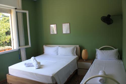 two beds in a room with green walls at Bridge To Venice in Venice