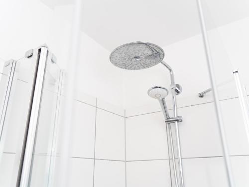 a shower with a shower head in a bathroom at Lottes Hus in Lübeck