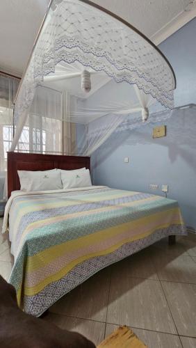 a bedroom with a bed with a canopy at Occazia Hotel in Mbarara