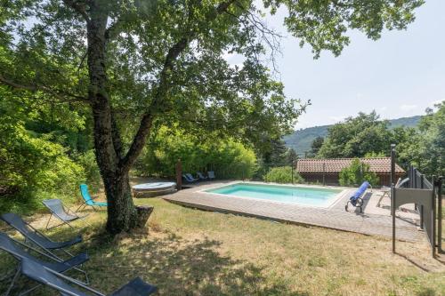 - une piscine dans une cour avec des chaises et un arbre dans l'établissement Chalet Blanc - Piscine Partagée, à Darbres