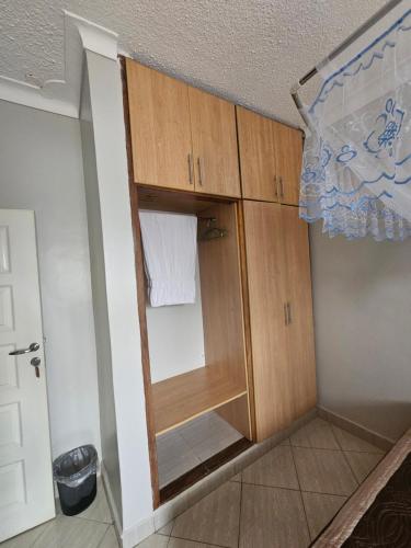 a closet with wooden cabinets in a room at Occazia Hotel in Mbarara