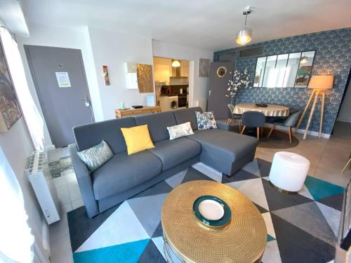 un salon avec un canapé bleu et une table dans l'établissement Appartement 3* rénové, 1 chambre, WIFI, à 200m plage de Trégastel, centre, vélos électriques offerts - FR-1-368-229, à Trégastel