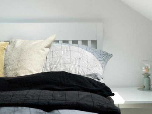 a bedroom with a bed with a pillow and a table at Lottes Hus in Lübeck