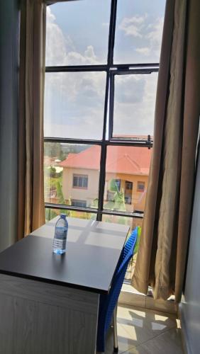 a table and chair in front of a window at Occazia Hotel in Mbarara