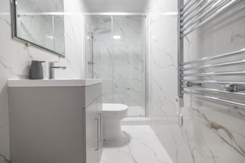 a white bathroom with a sink and a toilet at Boutique City Retreat Perfect for Business & Families With Free Gym By The Pocklington - The Filbert Suite in Leicester