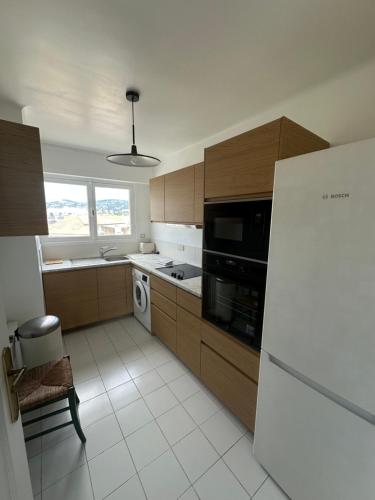 Il comprend une cuisine équipée d'un réfrigérateur et d'une cuisinière. four supérieur dans l'établissement Vue mer panoramique pour ce 3 pièces a 7 minutes a pied du palais du festival, à Cannes