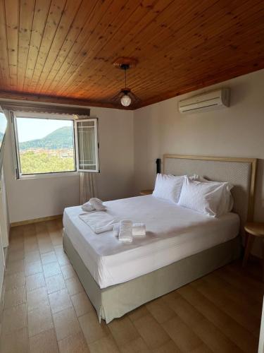 a bedroom with a large white bed with a window at Niriton Pension in Nydri