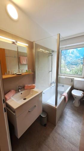 a bathroom with a tub and a sink and a toilet at Apartment Gastein 2 in Bad Gastein