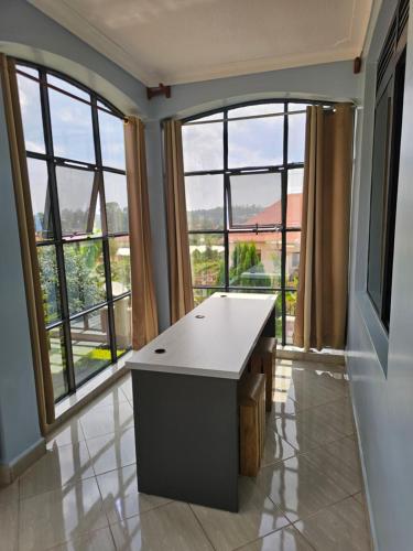 a room with large windows and a desk with a view at Occazia Hotel in Mbarara