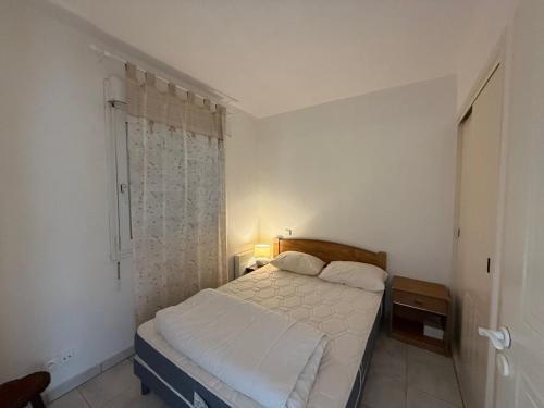une petite chambre avec un lit et une fenêtre dans l'établissement Appartement T2 avec piscine, balcon, parking privé - Moliets-et-Maa - FR-1-379-113, à Moliets-et-Maa