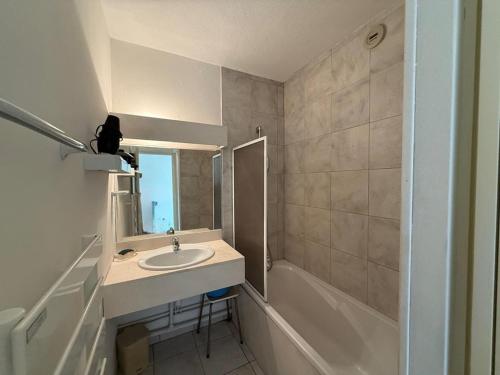une salle de bain avec un lavabo, une baignoire et un miroir dans l'établissement Appartement T2 avec piscine, balcon, parking privé - Moliets-et-Maa - FR-1-379-113, à Moliets-et-Maa