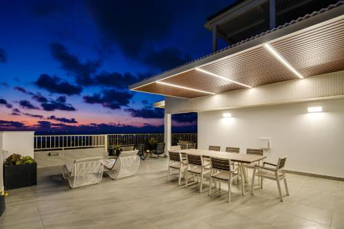 an outdoor patio with a table and chairs at night at The Sea View Penthouse Ashdod in Ashdod