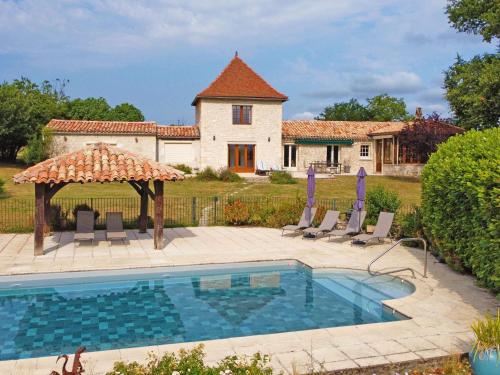 une piscine en face d'un bâtiment avec une maison dans l'établissement Propriété au calme avec piscine privée au cœur des vignes de Bergerac - FR-1-824-1, à Gageac-et-Rouillac