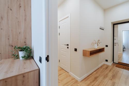 pasillo con puerta blanca y suelo de madera en Business-Ready NEW 1BR - Main Street Living, en Chişinău