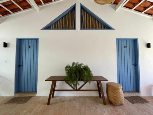 two blue doors and a table with a plant at Villa Tennis in Ubatuba