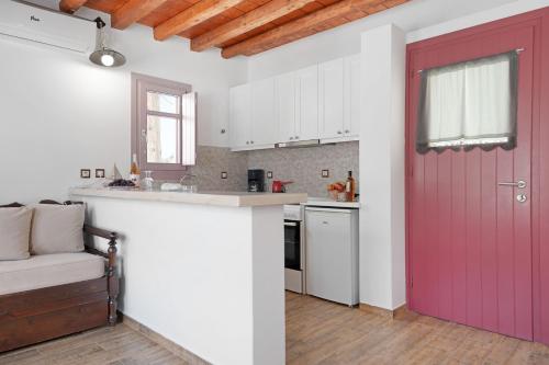 a kitchen with a red door and a counter at Nicolas House 1 in Rakhídhion