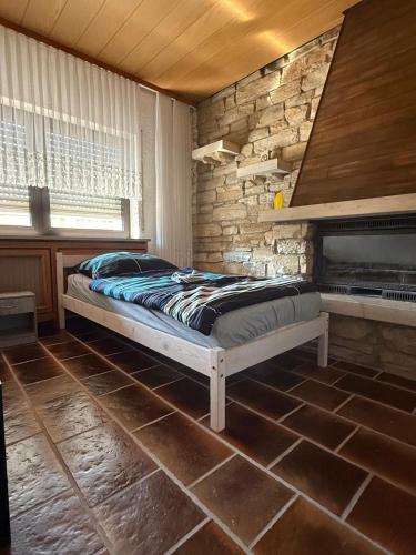 a bedroom with a bed and a stone wall at Monteur- und Ferienwohnung Ketsch in Ketsch