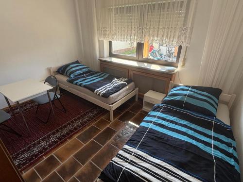 a bedroom with a bed and a table and a window at Monteur- und Ferienwohnung Ketsch in Ketsch