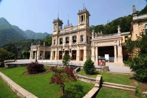 an old building with a garden in front of it at Casa Margherita in San Pellegrino Terme