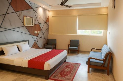 a bedroom with a bed and two chairs and a window at Curry garam cafe & Dhabha in Kharar