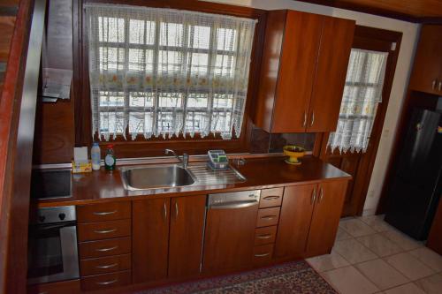 a kitchen with wooden cabinets and a sink and a window at Anna's House in Alexandroupoli