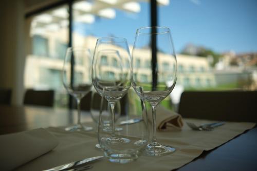 four empty wine glasses sitting on a table at Quinta da Maquia Hotel in Sintra