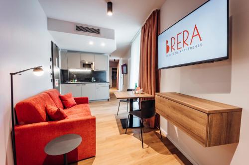 a living room with a red chair and a flat screen tv at Brera Serviced Apartments Böblingen Sindelfingen in Böblingen
