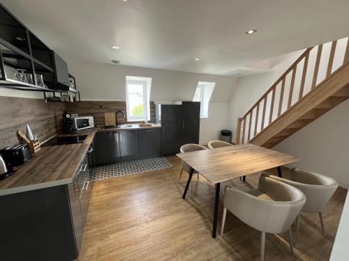 une cuisine et une salle à manger avec une table et des chaises en bois dans l'établissement La Perle de la Côte, à Boulogne-sur-Mer