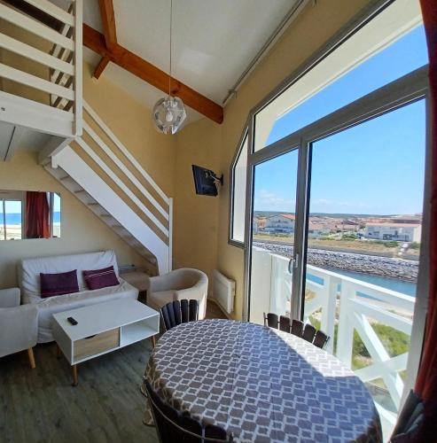 une chambre avec un lit et une grande fenêtre dans l'établissement Le Sunset, à Mimizan