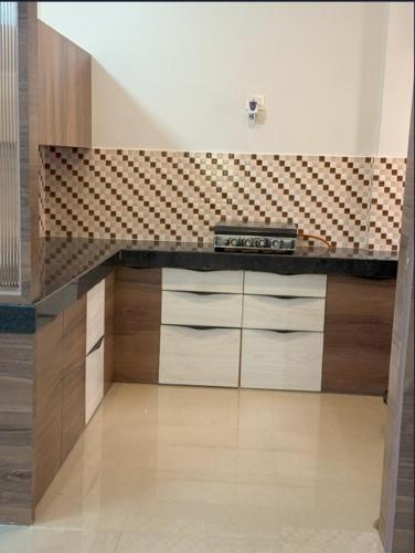 a kitchen with a counter top and wooden cabinets at Meet Home Stay For Family Or Female Only in Jaipur