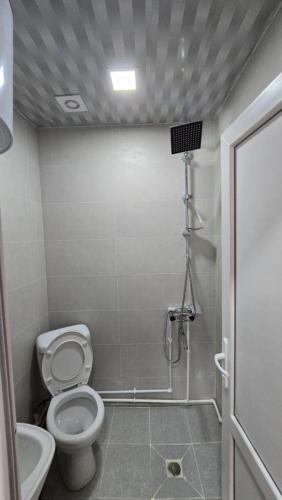a small bathroom with a toilet and a shower at Hotel Bakuna in Gulida