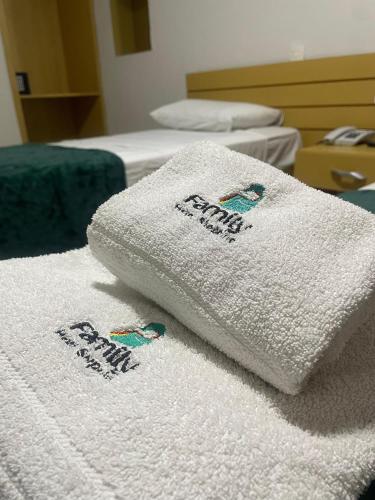 a pile of white towels sitting on a bed at Hotel Family São Paulo - No Shopping FAMILY - No Brás in Sao Paulo