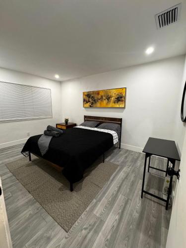 a bedroom with a black bed and a table at Santuaria Hollywood in Hollywood