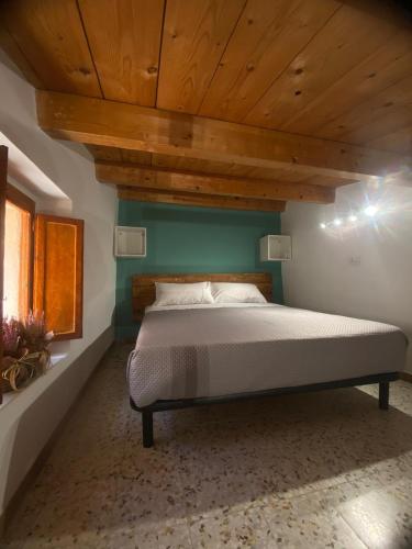 un letto in una stanza con soffitto in legno di Ai Sette Scalini a Larino