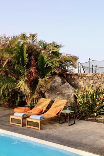 two lounge chairs sitting next to a swimming pool at Golden Wave Villa Lajares in Lajares