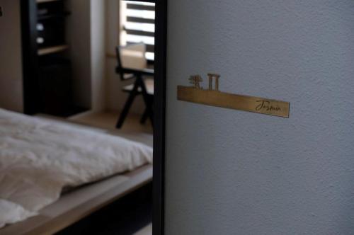 a door with a sign on it next to a bed at Jasmin錦町2F 高松駅近 畳の癒し空間 in Takamatsu