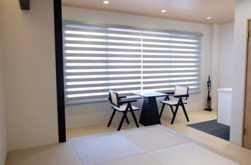 a dining room with a table and chairs in front of a window at Jasmin錦町2F 高松駅近 畳の癒し空間 in Takamatsu