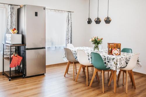 a dining room with a table and chairs and a refrigerator at Rodinný dům Alois in Hronov