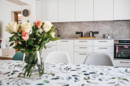 a vase of roses on a table in a kitchen at Rodinný dům Alois in Hronov