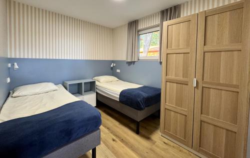 a small bedroom with two beds and a closet at Ośrodek Wczasowy Ostrów Pieckowski in Piecki