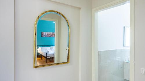 a mirror hanging on a wall in a bathroom at House Dafal by Rentbeat in Guidonia
