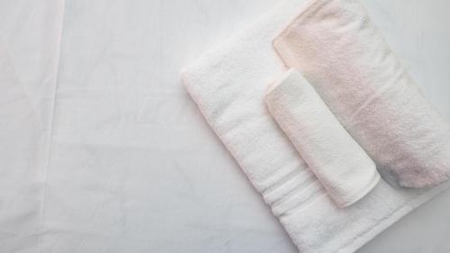 two white towels sitting on top of a table at House Dafal by Rentbeat in Guidonia