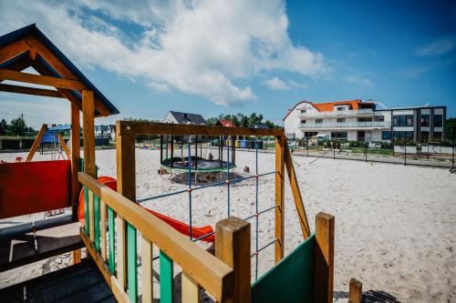 a playground on the beach with at Olivina Park Spa - domki z dostępem do krytego basenu, saun, wyżywienia i atrakcji dla dzieci in Niechorze
