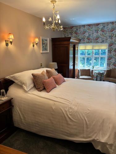 a bedroom with a large white bed with pillows at The Crown Inn Roecliffe in Roecliffe