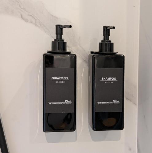 two bottles of shampoo and conditioner in a shelf at Green Heart Suites in Podljubelj