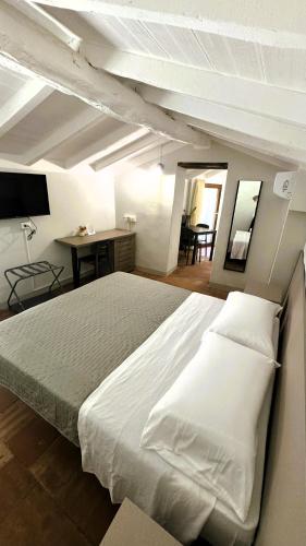 a bedroom with a large white bed with a desk at Residenze del Borgo in Zavattarello