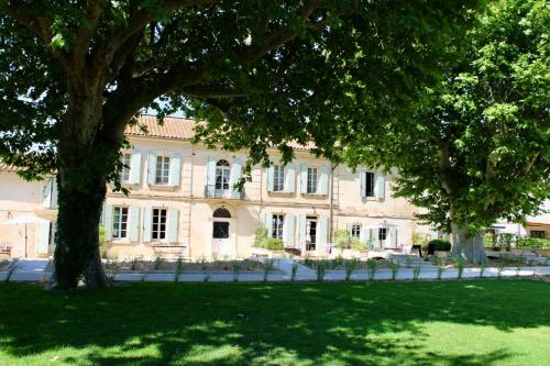 a large building with trees in front of it at Mas de l'Hermitage in Moulès