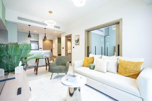 a living room with a white couch and a table at KeyRock Golf Gate - Relax and Unwind with Pool and Sauna in Dubai
