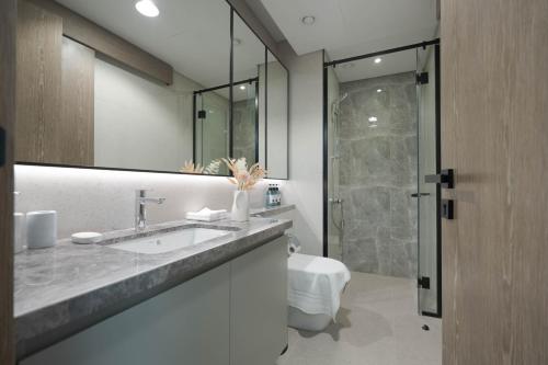 a bathroom with a sink and a toilet and a shower at KeyRock Golf Gate - Relax and Unwind with Pool and Sauna in Dubai